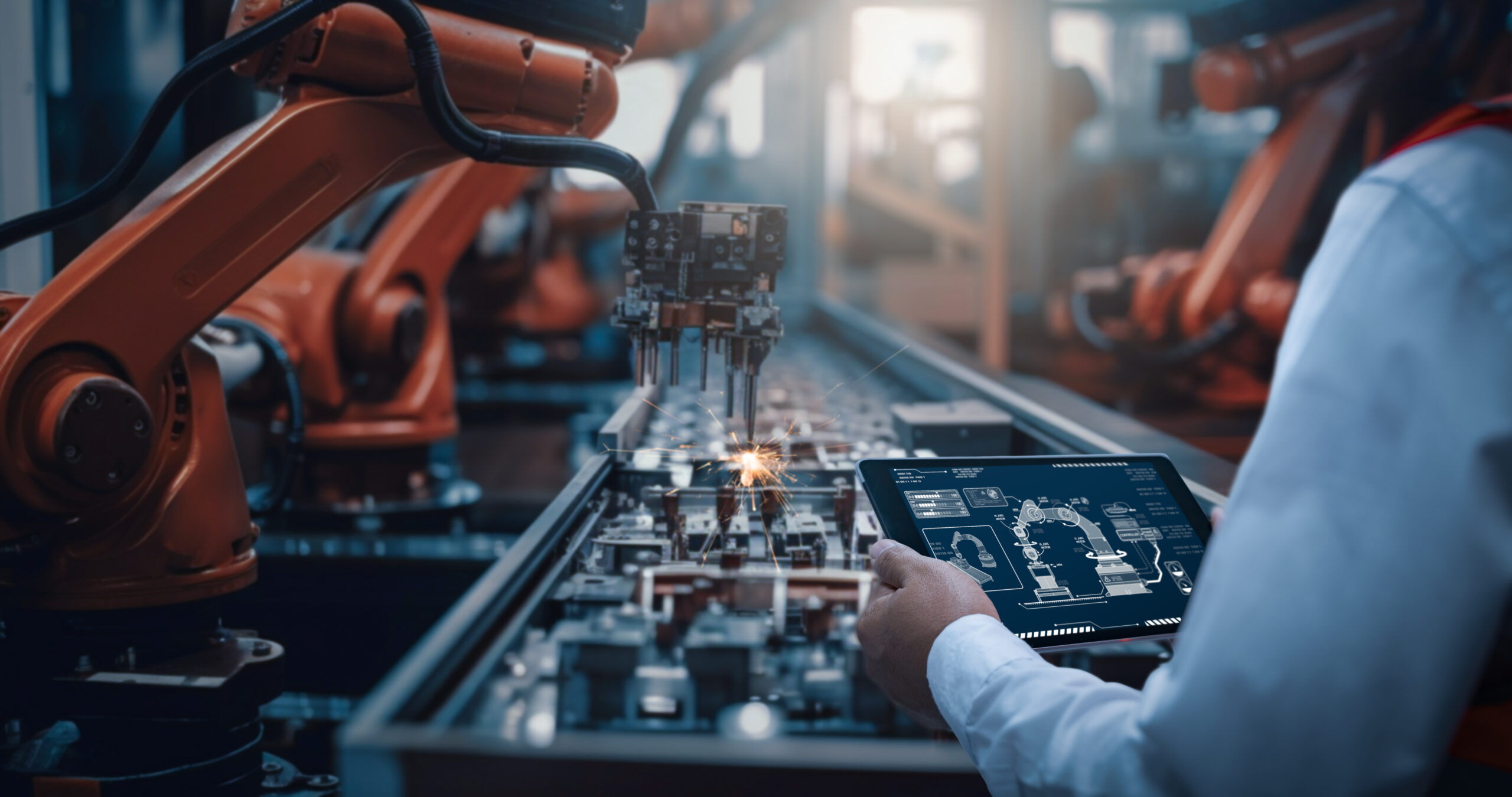 Engineers test the control of robot arm, Intelligent machine in factory industrial on real-time monitoring system software. Robots weld workpieces and produce industrial parts to reduce human labor Semiconductor manufacturing in a large factory